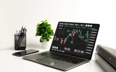 laptop screen show trading stock and display graph report for analysis growth stock to planning and decision to high profit and success corporate, working at home, smartphone on table, indoor office