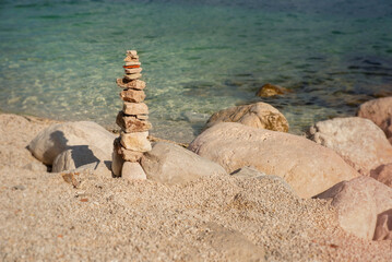 Fototapeta na wymiar Pyramid of stones on the coast of the Adriatic Sea