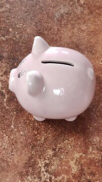 remplissage d'une tirelire cochon avec des euros