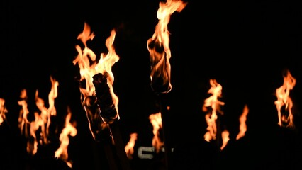 Flaming torches on the black background at night © Leon Colon Ortega/Wirestock Creators