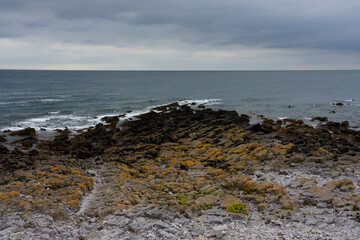 Fototapeta na wymiar Gloomy day on the rocky shores of Oxwich Bay.