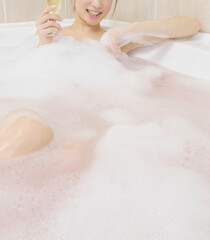 泡ぶろでシャンパンを飲む女性