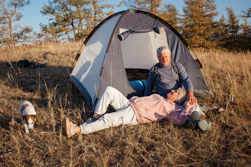 Camping tent vacation Senior couple man and woman sitting near camp tent.
