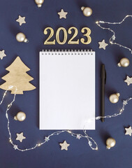 White sheet of notebook with pen on blue table. Concept planning, wish list for the new year....