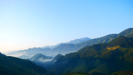 Beautiful Mountain landscape foggy windy mountain range green landscape asian farm. Amazing Landscape mountain green field meadow white cloud blue sky on sunrise. Countryside sunlight heaven scenery