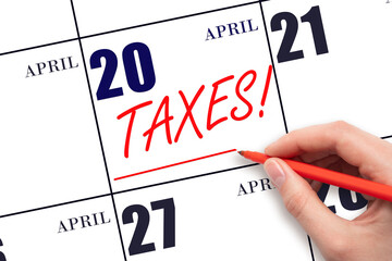 Hand drawing red line and writing the text Taxes on calendar date April 20. Remind date of tax payment
