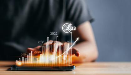 Businessman analyzes profitability of working company with digital virtual screen graphics. 2023...