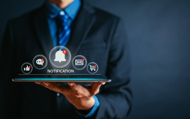 Businessman holding tablet with virtual bell ringing for application notification alert interface notice on mobile phone alarm concept.