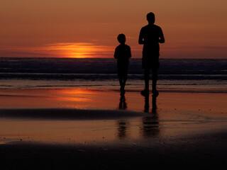 A father and son watching a sunset.