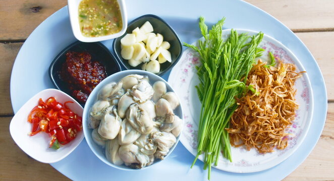 Fresh Oysters In Bowl With Acacia Leaf And Fried Slice Shallot Dipping Spicy Sauce