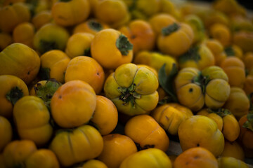 Naklejka na ściany i meble Persimmons on market. Healthy food. Fruits in shop. Yellow fruits.