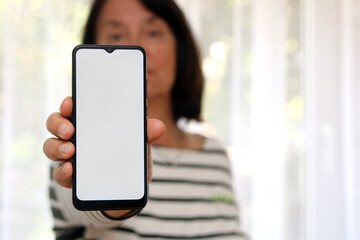 Frau zeigt das leere Display ihres Handys