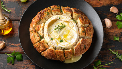 Baked Camembert cheese in sourdough bread with rosemary, garlic, thyme
