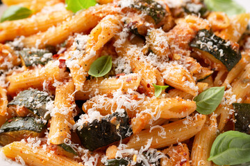 Zucchini penne pasta with parmesan cheese, basil and tomato. Healthy food