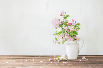 apple flowers in white jug on background grunge wall