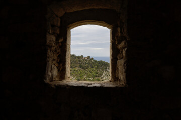 Details with the view from a window inside a mediaeval fortress on the French riviera during a cloudy spring day.