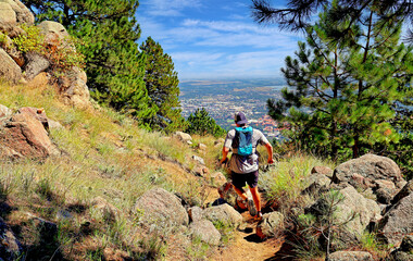 A trail runner jogs down a path on Flagstaff Mountain, Boulder, Colorado 
