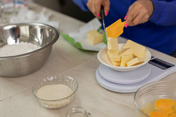 Woman weighing butter on a scale, to prepare bread