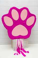 pink cat's paw, birthday piñata, toy piñata with sweets on white background