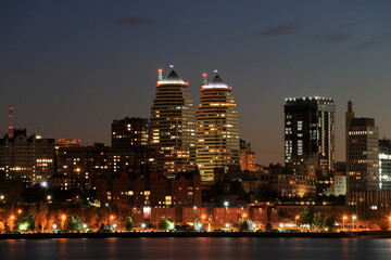 Obraz premium Big city at night. Beautiful modern buildings, skyscrapers and towers are reflected in Dnipro river evening, Ukraine. Dnepr.