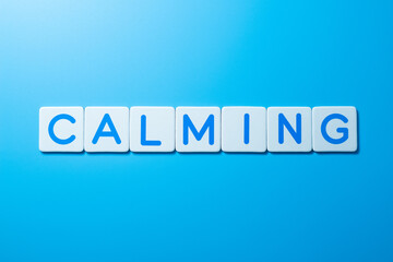 Word CALMING over a blue background,CALMING Concept