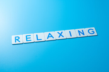 Word RELAXING on blue background,RELAXING Concept