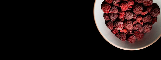 Top view of frozen raspberries inside glass plate on the black background. healthcare, healthy food concept, Flat lay Ripe berries with frosty freshness, agriculture. soft focus, selective focus.