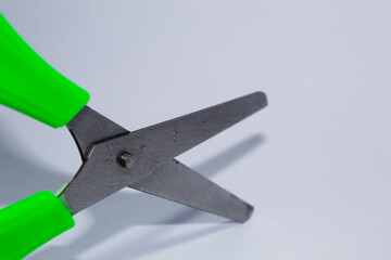 Metal scissors with green plastic parts