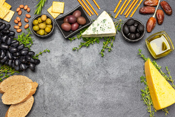 Appetizer for an aperitif with olives and cheese, grapes and dates, baguette and crackers, nuts and...