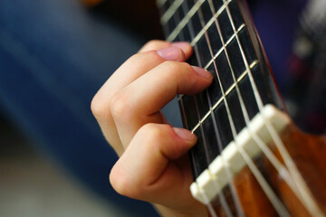 playing the guitar. Fingers on guitar strings