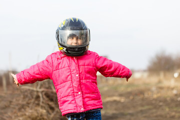 portrait of a little girl smiling in a protective helmet female child in motocross moto helmet....