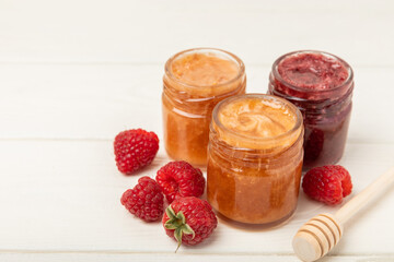 Honey in a glass jar. Raspberry and blueberry honey jam. Remedy for colds and respiratory diseases. Organic product of a vegetarian diet. copy space. copy space