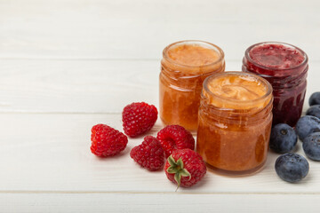 Honey in a glass jar. Raspberry and blueberry honey jam. Remedy for colds and respiratory diseases. Organic product of a vegetarian diet. copy space. copy space