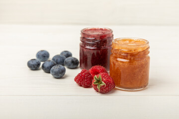 Honey in a glass jar. Raspberry and blueberry honey jam. Remedy for colds and respiratory diseases. Organic product of a vegetarian diet. copy space. copy space