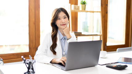 Businesswoman using laptop to work, Asian woman working in the office, Financial clerk or accountant with documents and equipment working on the desk, Using computers for financial transactions.