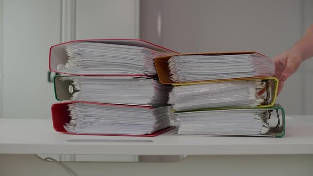 In the office, four employees throw folders with documents on the table