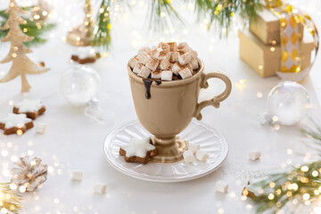 Cup of hot chocolate with marshmallow, cookies and cinnamon on festive table. Tradition Christmas...