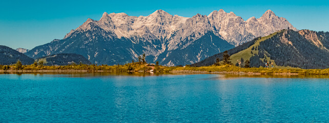 Beautiful alpine summer view with the famous Loferer Steinberge mountains in the background and reflections in a lake at Fieberbrunn, Tyrol, Austria