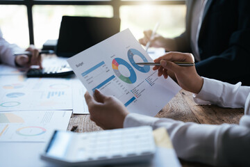 Close-up of Team business were analyzing a budget in charts diagrams and graphs, Finance and group meeting concept.
