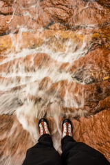Water Rushes Around Canyoneering Boots On Orange Rock