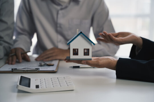 real estate agent or salesman holds a house model to describe the details of the house to customer, Real estate trading ideas.