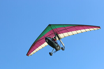 Ultralight airplane flying in a blue sky	