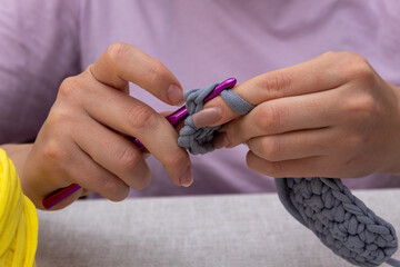 Women's fingers hold the hook while knitting. Close-up. Selective focus. Images for websites about...