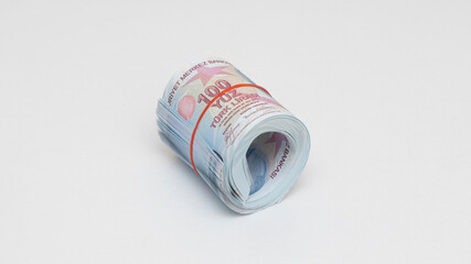 Hundred Turkish liras rolled up with rubber band on isolated white background