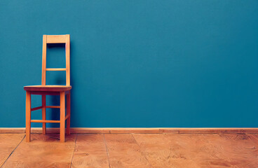 Silla de madera, fondo azul, piso de madera