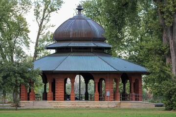 Antiquated stone gazebo in a park.