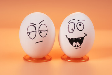 Two eggs with worried and carefree faces