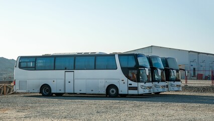 Row of luxury buses parked on the construction site for transporting a team © Albert Karimov/Wirestock Creators