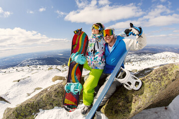 Happy snowboarding  couple in winter mountains