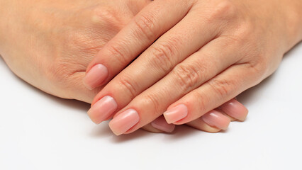 Women's hands with transparent nail polish close-up. The concept of care for the skin of the hands and nails